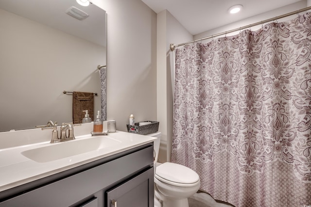 bathroom with toilet, curtained shower, vanity, and visible vents