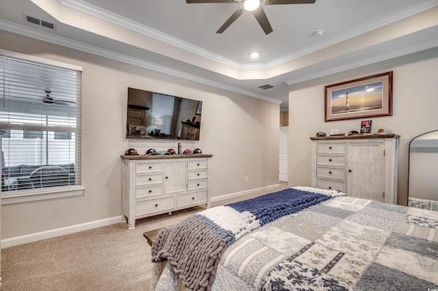 bedroom with a tray ceiling, crown molding, visible vents, carpet flooring, and baseboards