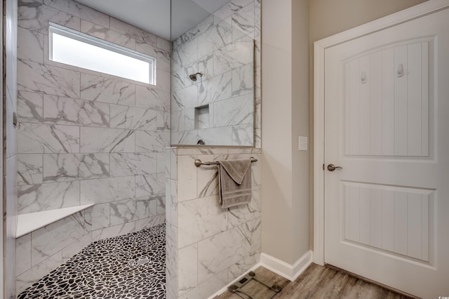 bathroom with baseboards, a walk in shower, and wood finished floors