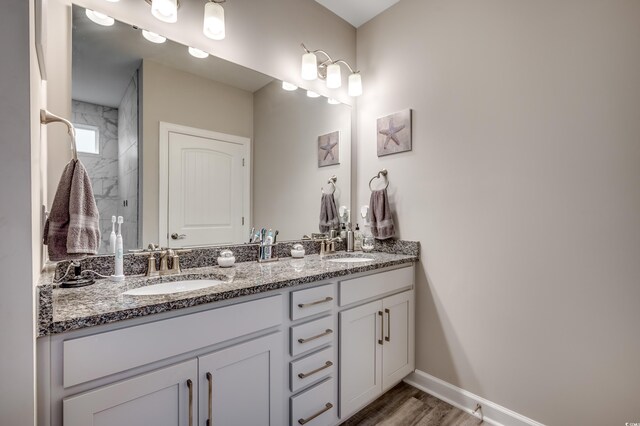 2023 Singing Palm Loop, Little River, SC 29566 - bathroom featuring double vanity, baseboards, wood finished floors, and a shower