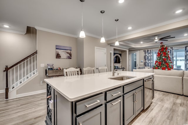 kitchen featuring an island with sink, light wood-type flooring, open floor plan, and a sink