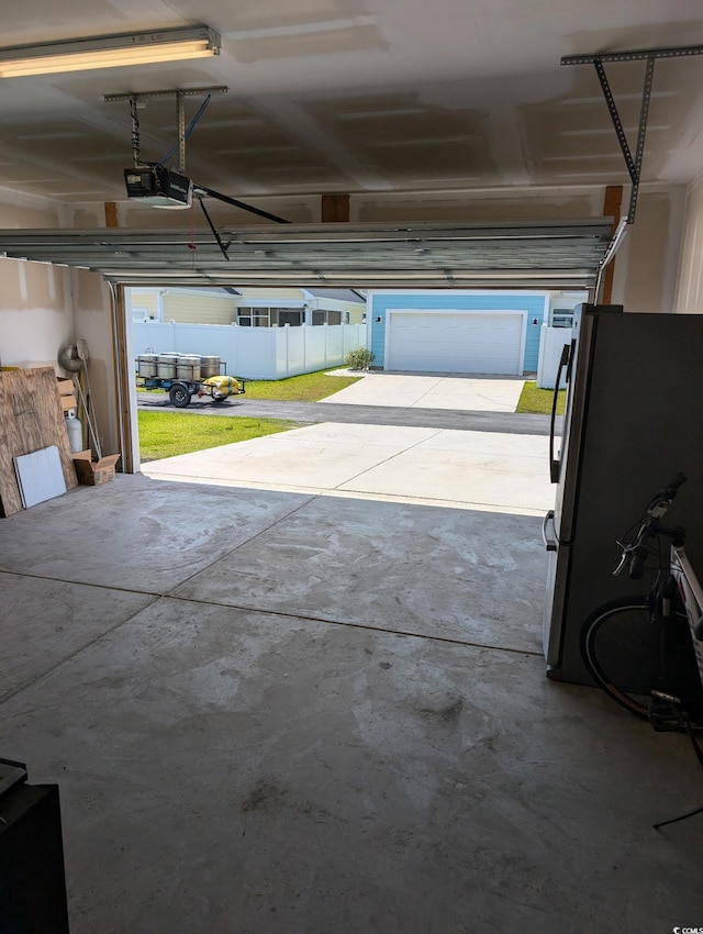 2023 Singing Palm Loop, Little River, SC 29566 - garage featuring a garage door opener and freestanding refrigerator