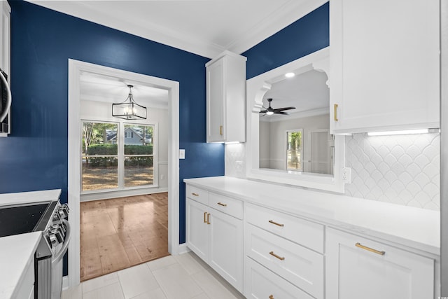 kitchen featuring crown molding, white cabinets, light hardwood / wood-style floors, and stainless steel range oven