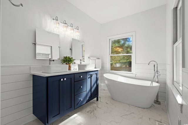 bathroom featuring a bathing tub, vanity, and tile walls