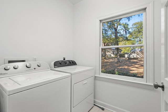 laundry room featuring plenty of natural light, separate washer and dryer, and light tile patterned floors