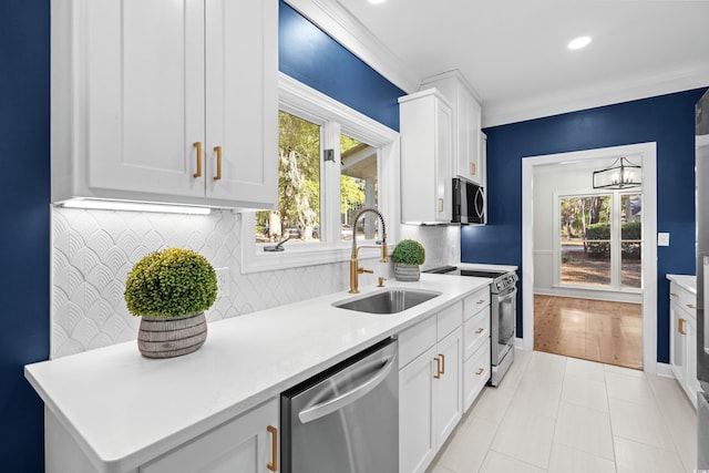 kitchen featuring backsplash, white cabinetry, sink, and stainless steel appliances