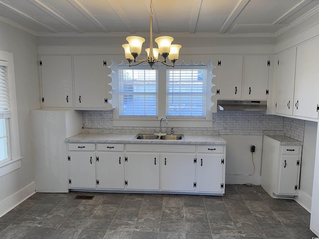 kitchen featuring pendant lighting, white cabinetry, sink, and a chandelier