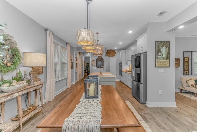 living room with light hardwood / wood-style floors and a notable chandelier