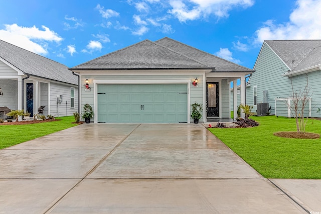 ranch-style house with a garage, concrete driveway, roof with shingles, a front lawn, and central AC