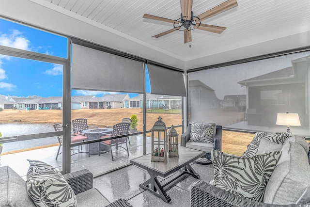 sunroom featuring ceiling fan, a water view, and wooden ceiling