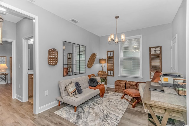 sitting room featuring light wood-style floors, visible vents, and baseboards