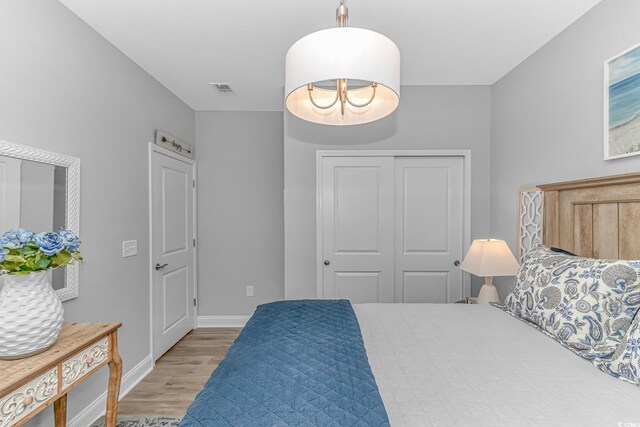 bedroom featuring a chandelier and light hardwood / wood-style flooring