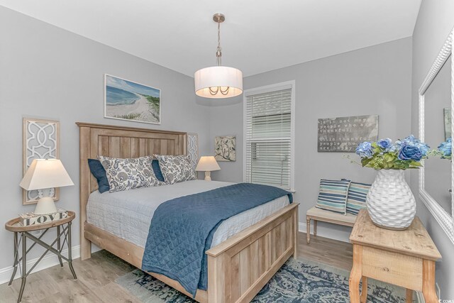 bedroom with a notable chandelier and hardwood / wood-style floors