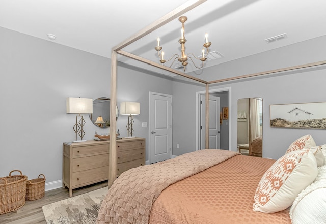 bedroom with light wood-style floors, a chandelier, visible vents, and baseboards