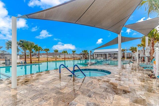 view of swimming pool with a hot tub and a patio area