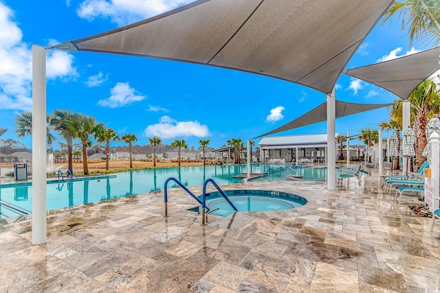 pool with a patio and a hot tub