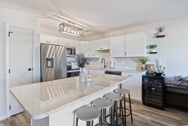 kitchen featuring white cabinets, light wood-type flooring, and stainless steel appliances