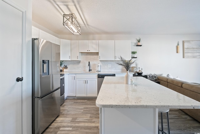 kitchen featuring white cabinets, stainless steel appliances, and light wood-type flooring