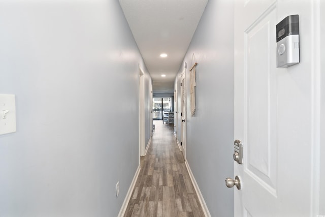 hallway with hardwood / wood-style floors