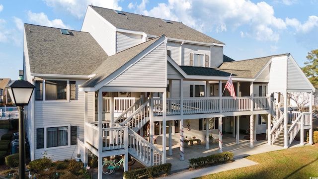 rear view of property featuring a patio area, a yard, and a deck