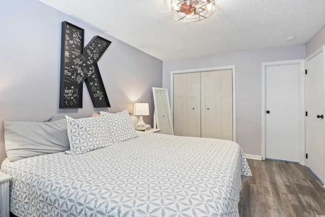 bedroom with a closet, wood-type flooring, and a textured ceiling