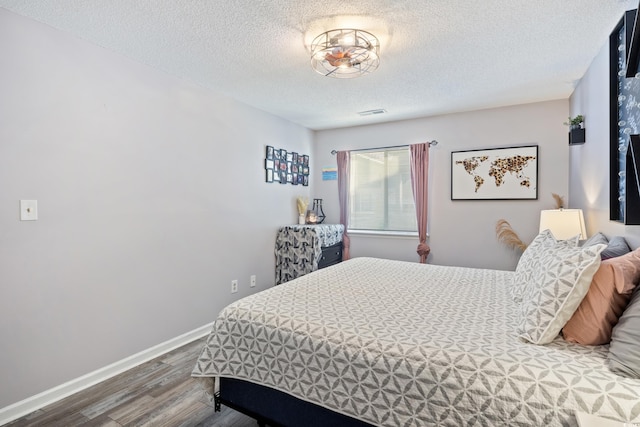 bedroom with hardwood / wood-style floors and a textured ceiling