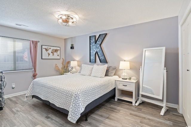 bedroom featuring wood-type flooring and a textured ceiling