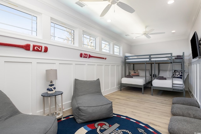 bedroom with multiple windows, ceiling fan, light hardwood / wood-style floors, and ornamental molding