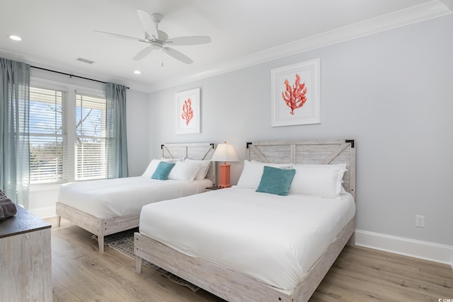 bedroom featuring light hardwood / wood-style flooring, ceiling fan, and crown molding