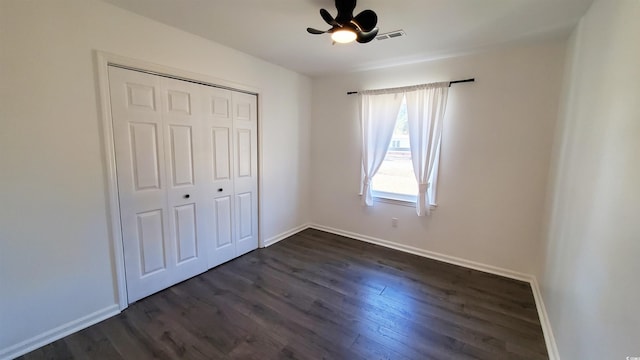 unfurnished bedroom featuring ceiling fan, a closet, and dark hardwood / wood-style floors