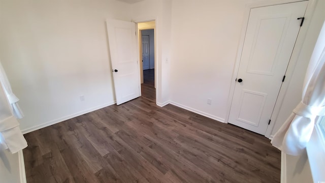 unfurnished bedroom with dark wood-type flooring