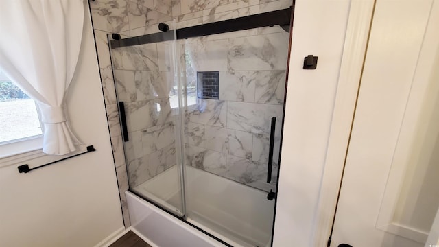 bathroom featuring shower / bath combination with glass door