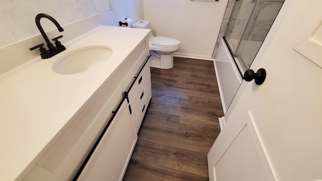 full bathroom with hardwood / wood-style flooring, vanity, toilet, and shower / bath combination with glass door