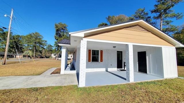 back of house featuring a lawn and a patio area