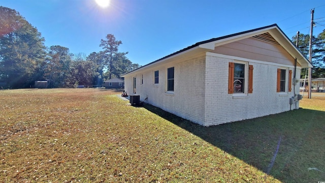 view of home's exterior with a yard and central AC