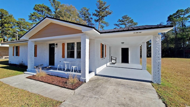 90 Wateree Trl, Georgetown, SC 29440 - bungalow with a front yard, a carport, a porch, metal roof, and brick siding