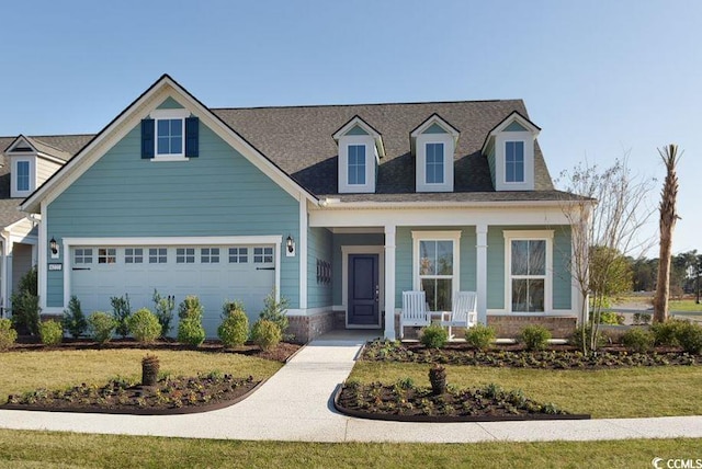 view of front of home with a porch, a garage, and a front lawn