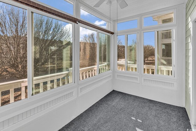 unfurnished sunroom featuring ceiling fan