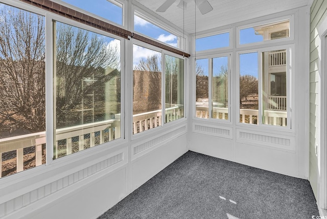 unfurnished sunroom featuring ceiling fan