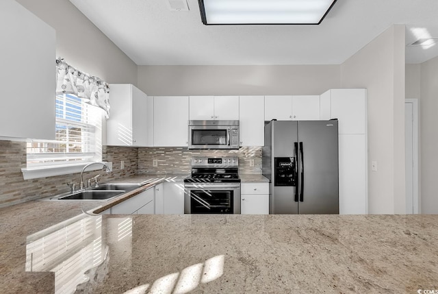 kitchen with backsplash, appliances with stainless steel finishes, sink, and white cabinets