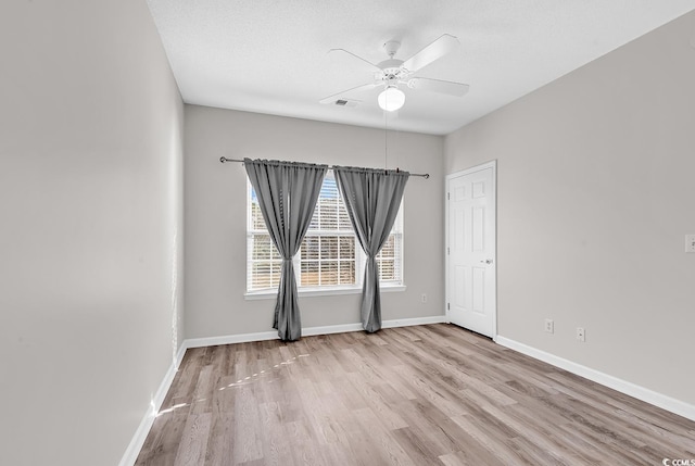 unfurnished room featuring ceiling fan, light hardwood / wood-style flooring, and a textured ceiling