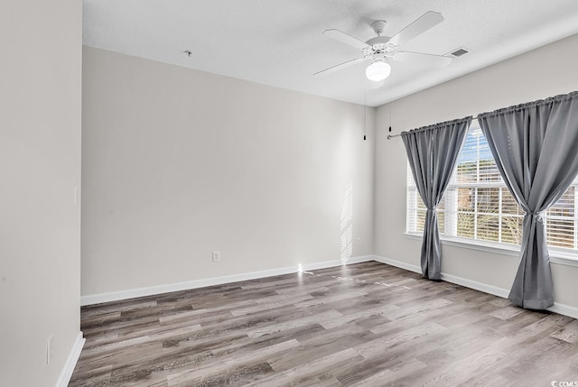 spare room featuring wood-type flooring, a textured ceiling, and ceiling fan