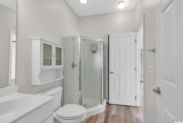 bathroom with vanity, wood-type flooring, an enclosed shower, and toilet