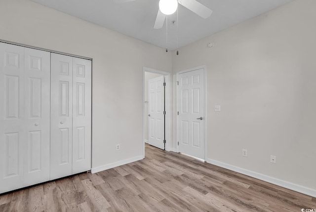 unfurnished bedroom featuring ceiling fan, light hardwood / wood-style floors, and a closet