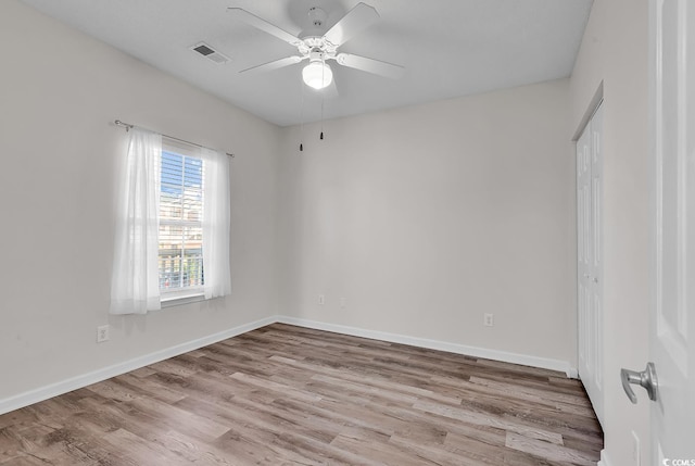 spare room with ceiling fan and light wood-type flooring