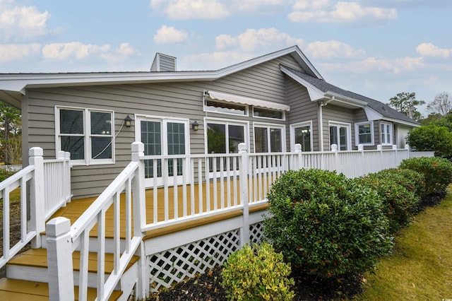 view of front facade with a chimney and a wooden deck