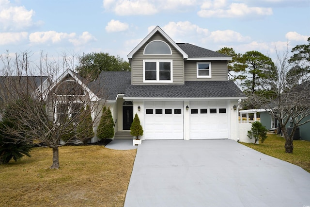 traditional-style house with driveway, a garage, a front lawn, and roof with shingles