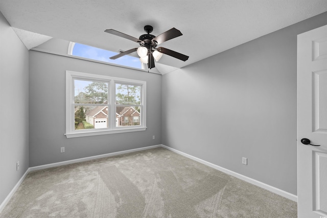 carpeted empty room with a textured ceiling, ceiling fan, and vaulted ceiling