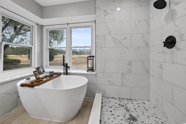 bathroom featuring a freestanding bath, tiled shower, and wood finished floors