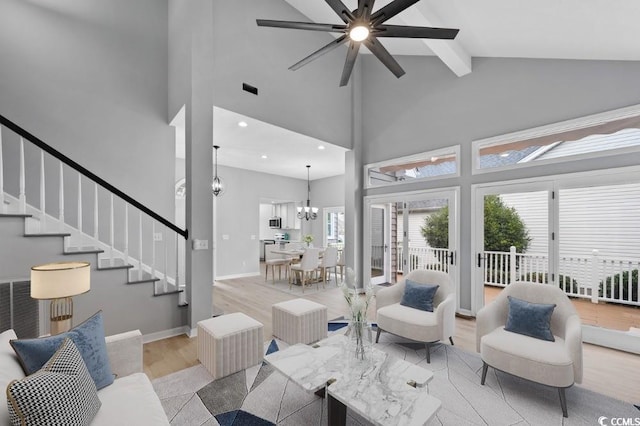 living room with high vaulted ceiling, wood finished floors, baseboards, stairs, and beam ceiling